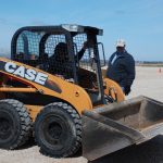 Operator of a Case skid steer receiving safety training from an instructor.