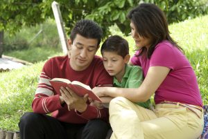 Latino family reading a book