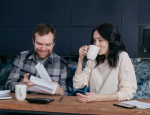 A man and a woman smiling while looking at important papers