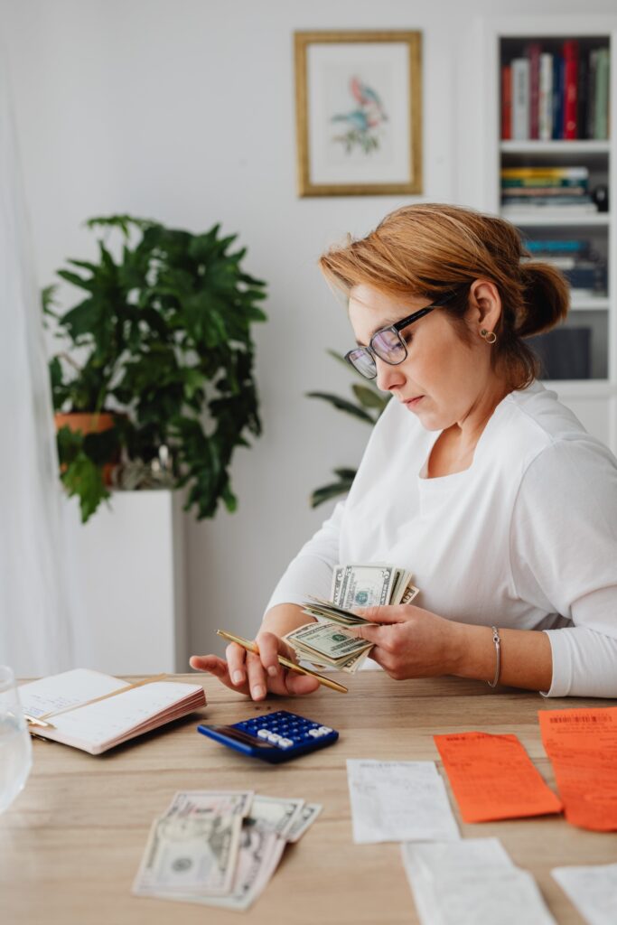 Woman counting money to pay bills