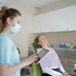 Dental assistant with patient