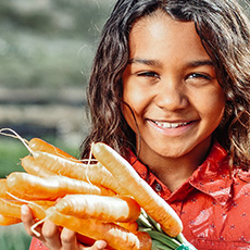 young girl holding carrots