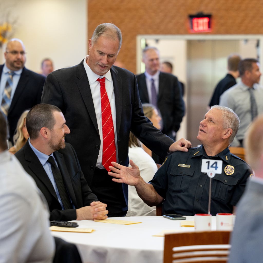 Wentlandt talks with attendees seated at a table