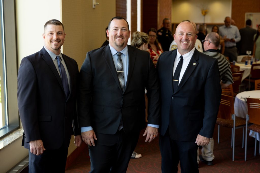 Three Command College graduates pose for a picture after graduation