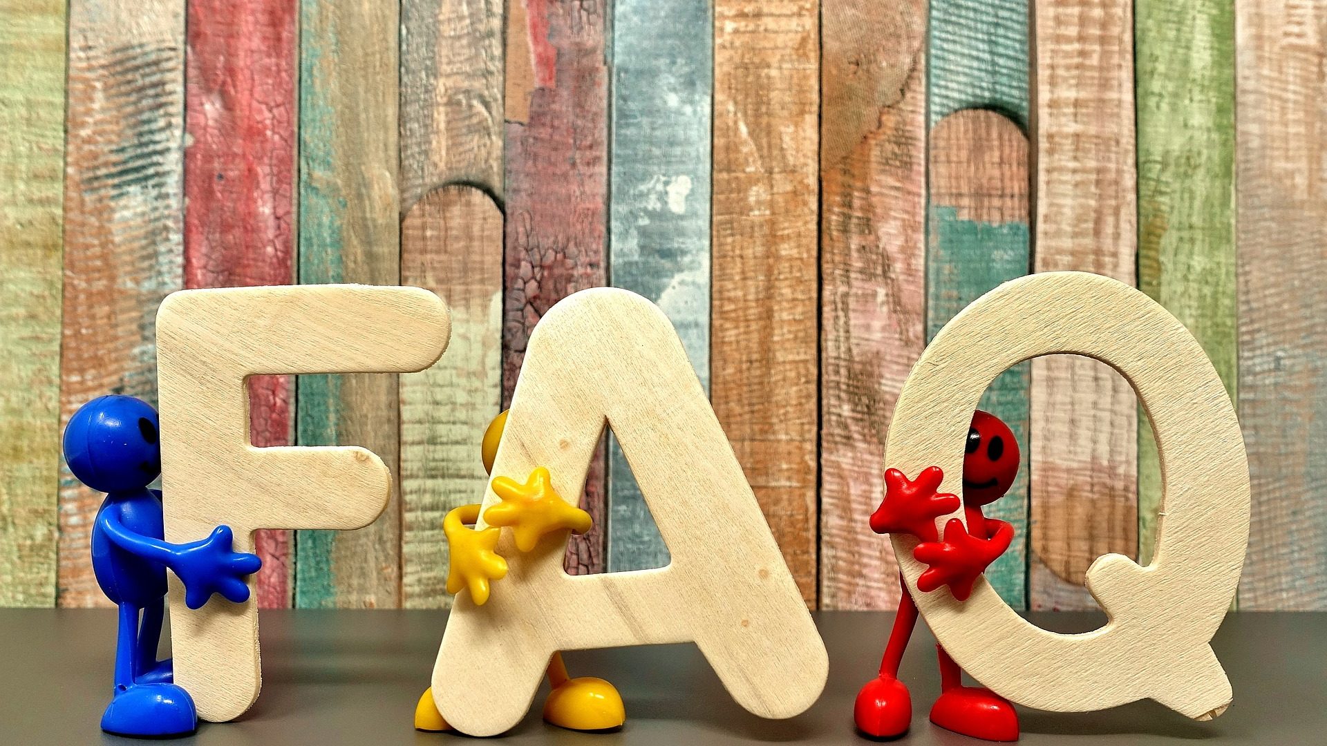 The letters FAQ being held by multi colored figures